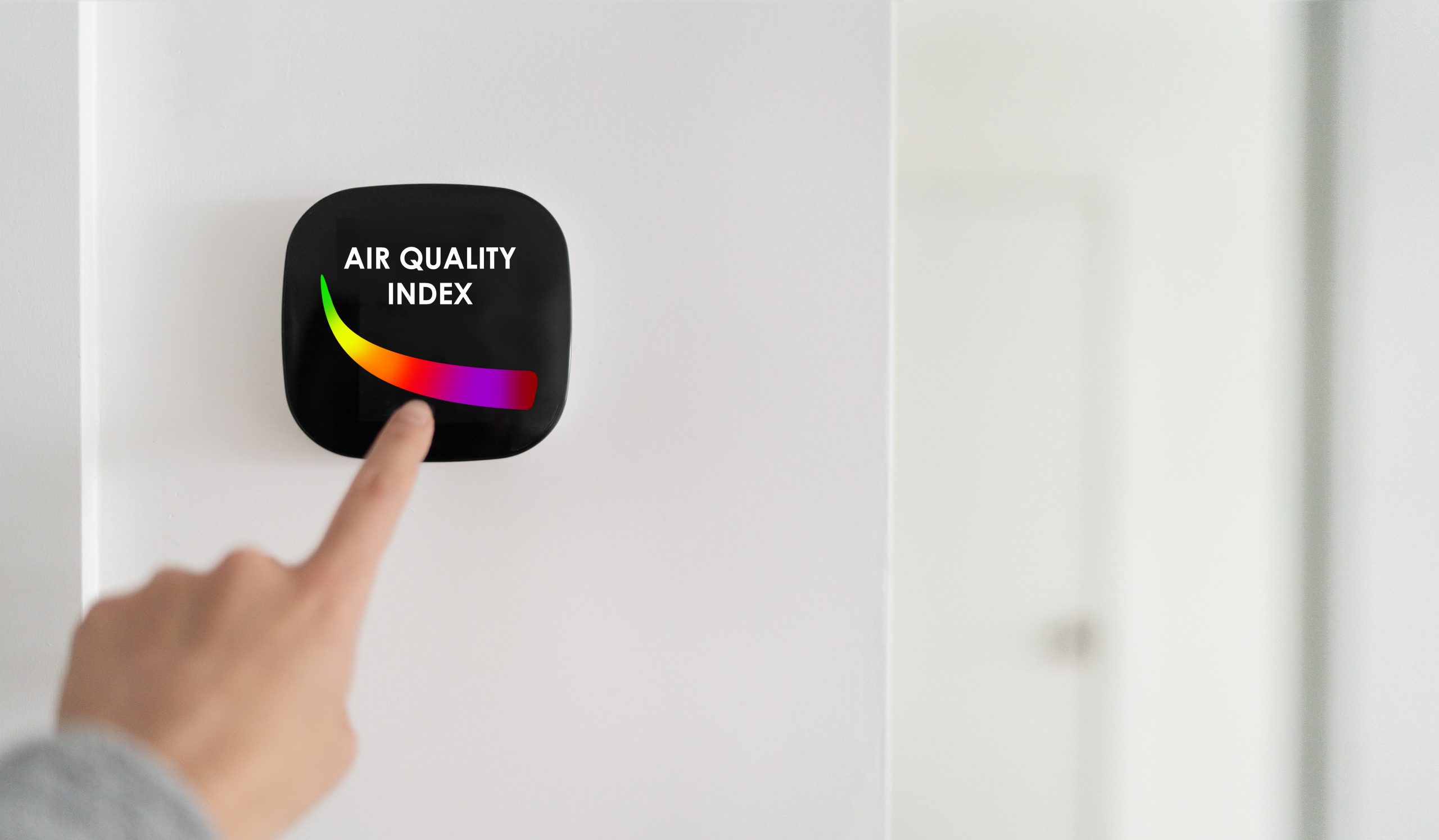 Air quality index showing on smart home domotic tech device. Woman touching touchscreen for clean air breathing purifying filter.