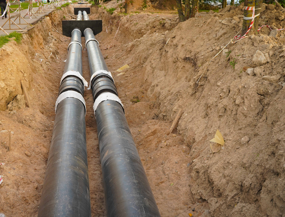 Replacement main sewer line for a residential neighborhood, pipes exposed within a dirt